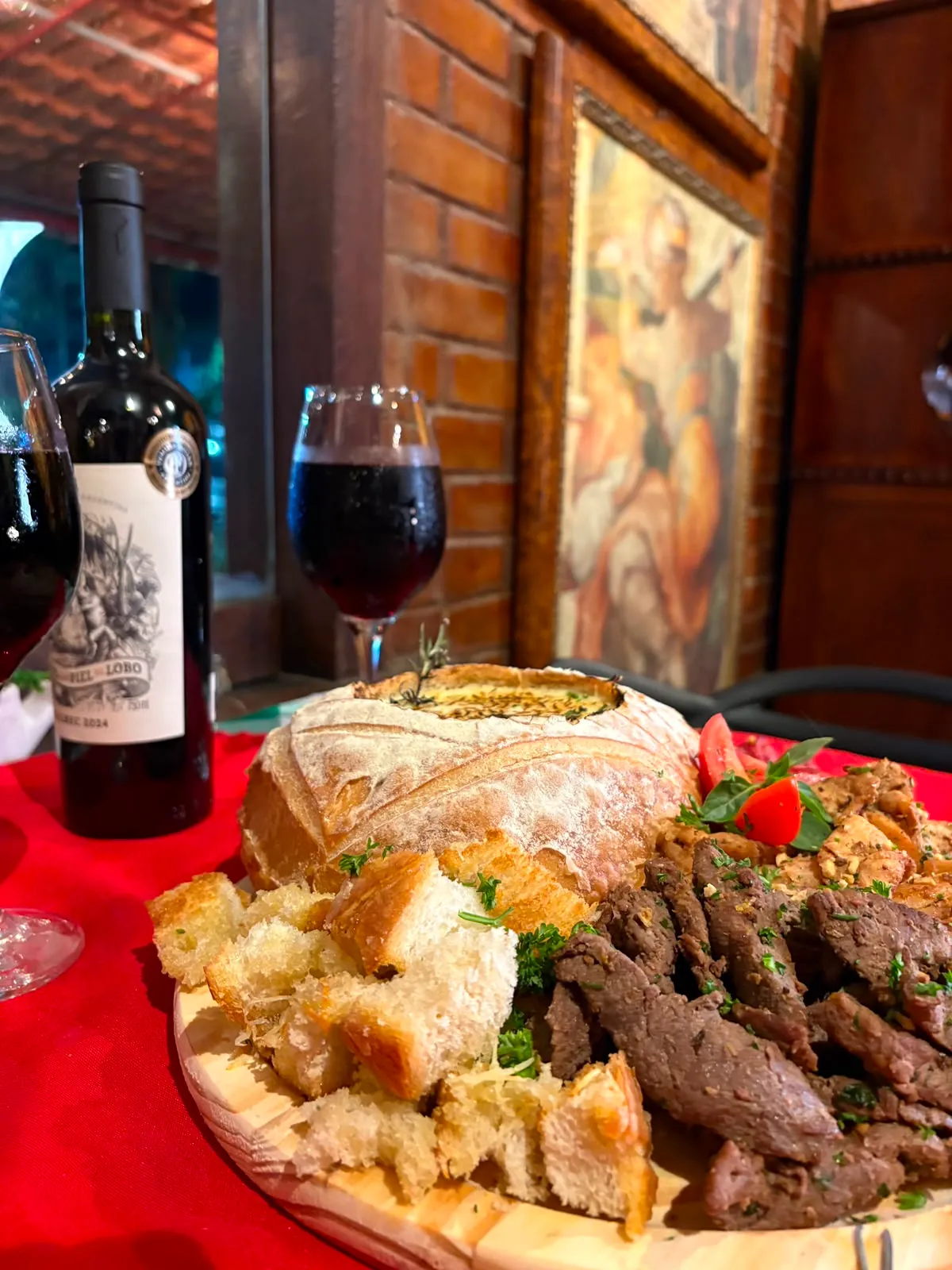 Tábua de carnes com pão italiano e vinho tinto da Casa Piatto